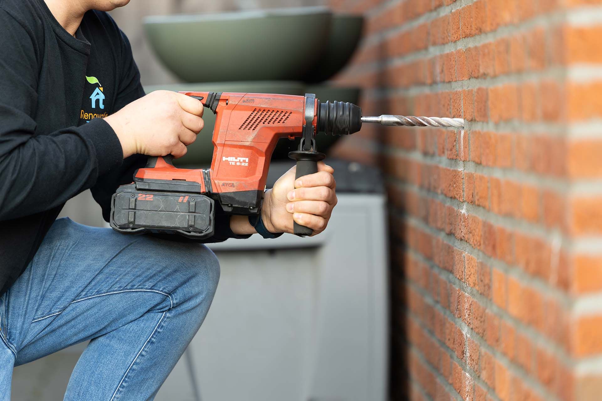 Monteur blaast spouwmuurisolatie in bij een woning in Hoofddorp